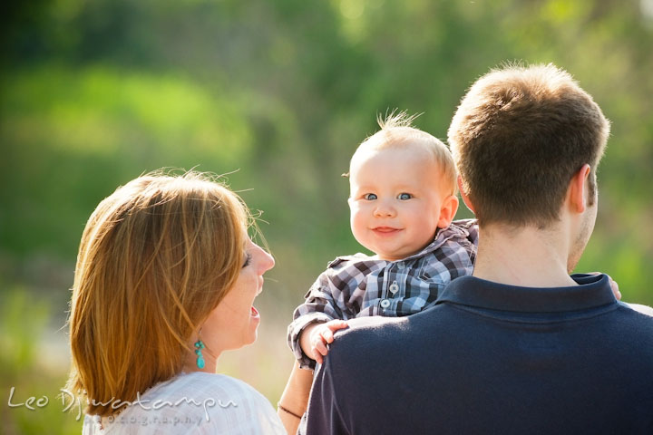 Father holding up his baby boy. Baby looking at camera. Mother laughing. Eastern Shore Maryland Kent Island Family Lifestyle Portrait Photo Session by Photographer Leo Dj Photography