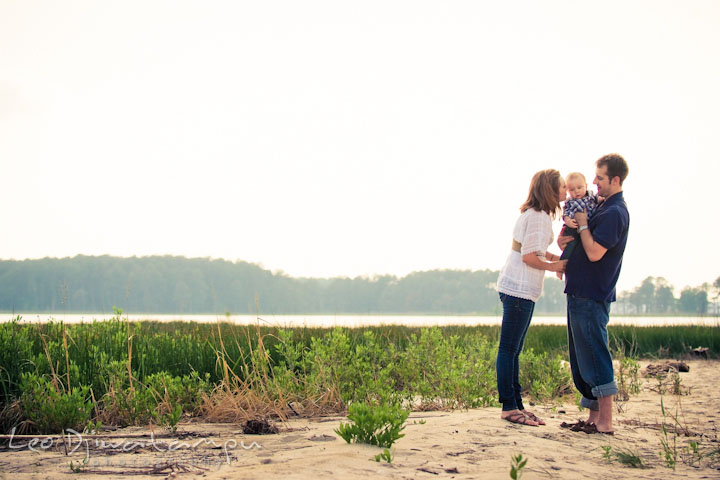 Father and mother on the beach, holding their baby. Eastern Shore Maryland Kent Island Family Lifestyle Portrait Photo Session by Photographer Leo Dj Photography