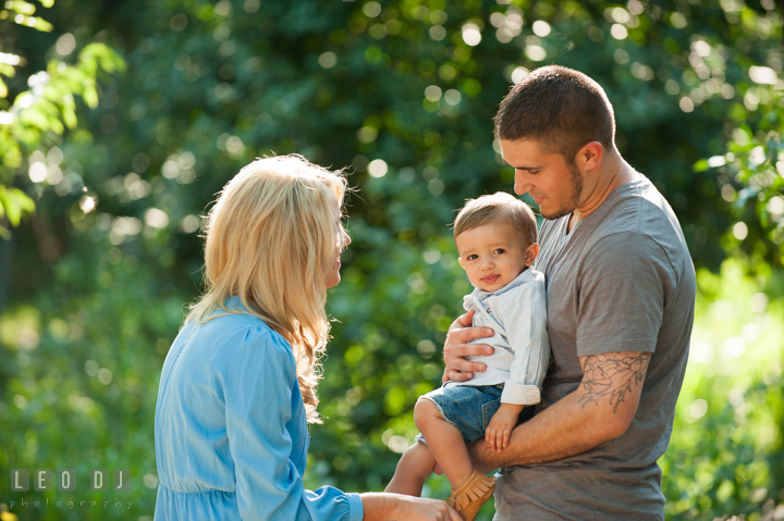 Dad carrying son, while Mom talks to him. Kent Island, Annapolis, Eastern Shore Maryland candid children and family lifestyle portrait photo session by photographers of Leo Dj Photography. http://leodjphoto.com