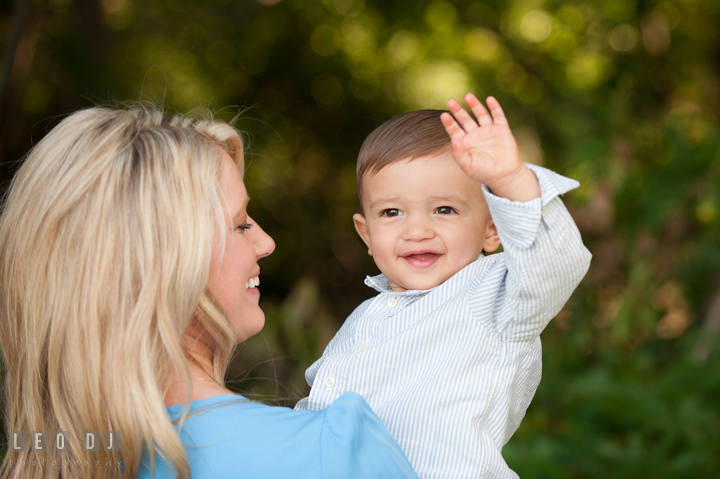 Mother carrying son who is waving his hands. Kent Island, Annapolis, Eastern Shore Maryland candid children and family lifestyle portrait photo session by photographers of Leo Dj Photography. http://leodjphoto.com