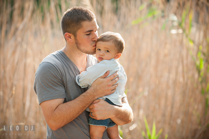 Father carrying son and kissing him on his forehead. Kent Island, Annapolis, Eastern Shore Maryland candid children and family lifestyle portrait photo session by photographers of Leo Dj Photography. http://leodjphoto.com