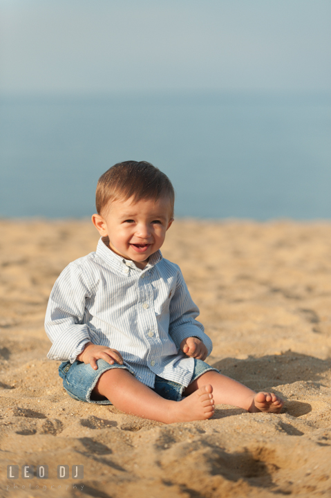 Little toddler boy sitting on the beach sand. Kent Island, Annapolis, Eastern Shore Maryland candid children and family lifestyle portrait photo session by photographers of Leo Dj Photography. http://leodjphoto.com