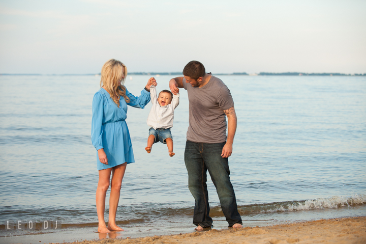 Mom and Dad on the beach playing together with their Son lifting him up. Kent Island, Annapolis, Eastern Shore Maryland candid children and family lifestyle portrait photo session by photographers of Leo Dj Photography. http://leodjphoto.com