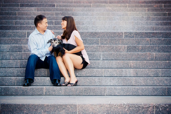 Engaged couple posing with their dogs on a stair. National Harbor, Gaylord National Hotel pre-wedding engagement photo session