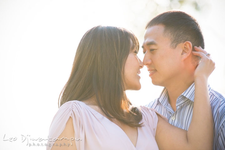 A guy and his fiancée cuddling. National Harbor, Gaylord National Hotel pre-wedding engagement photo session