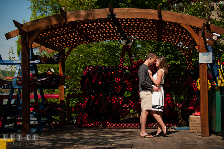 Engaged guy hugging his fiancée under a canopy. Georgetown Washington DC pre-wedding engagement photo session, by wedding photographers of Leo Dj Photography. http://leodjphoto.com