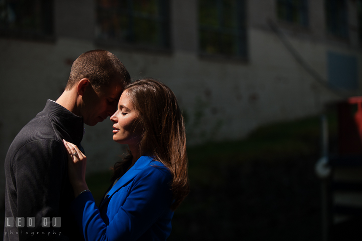 Engaged girl cuddling with her fiancé by the C&O Canal. Georgetown Washington DC pre-wedding engagement photo session, by wedding photographers of Leo Dj Photography. http://leodjphoto.com