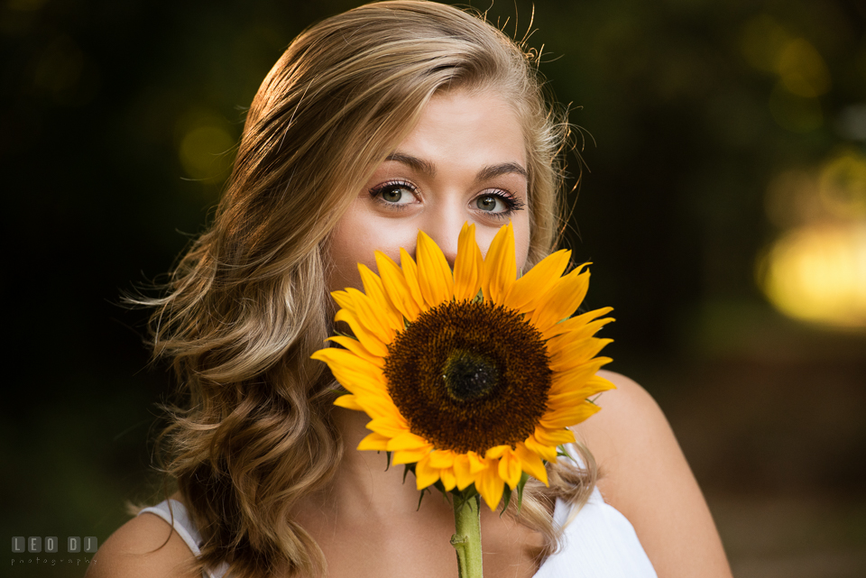 Kent Island High School Maryland senior with beautiful eyes behind sunflower photo by Leo Dj Photography