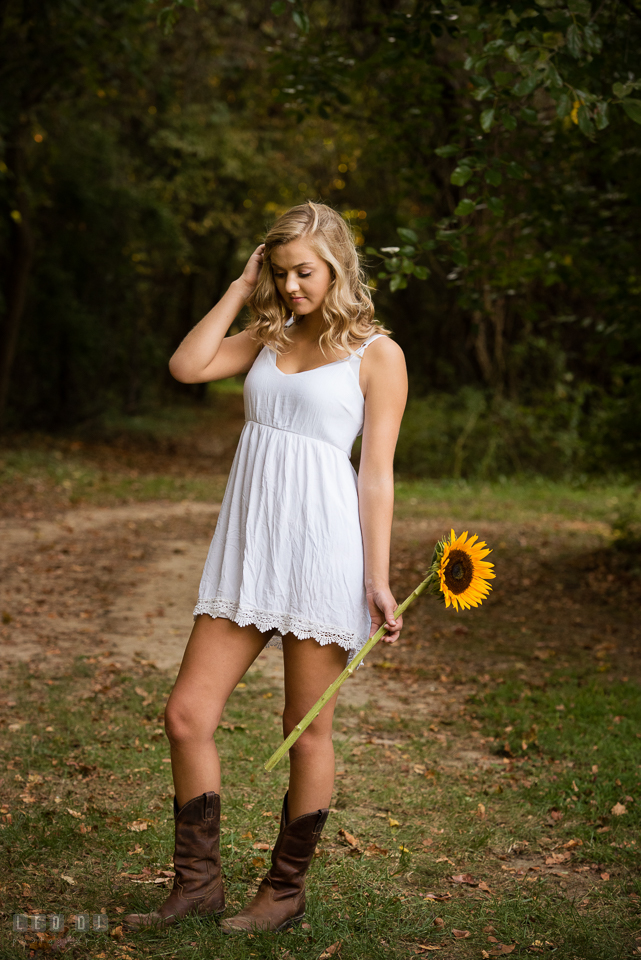 Kent Island High School Maryland senior with sunflower brushing hair photo by Leo Dj Photography