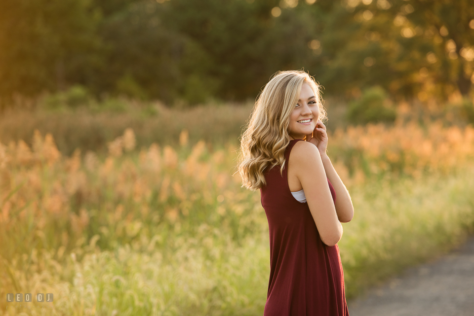 Kent Island High School Maryland senior in grass field smiling photo by Leo Dj Photography