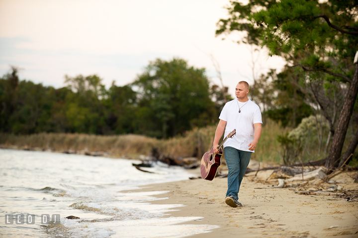 Guy carrying guitar walking on the beach. Eastern Shore, Maryland, Kent Island High School senior portrait session by photographer Leo Dj Photography. http://leodjphoto.com