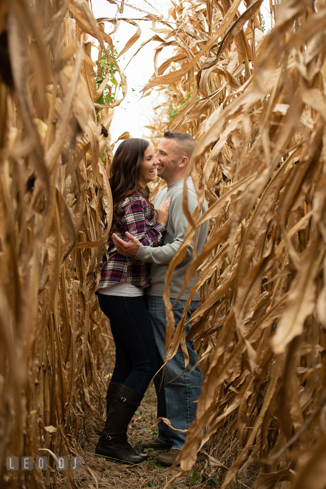 Wye Island Queenstown Maryland couple hugging and laughing in between corn stalk engagement photo by Leo Dj Photography.