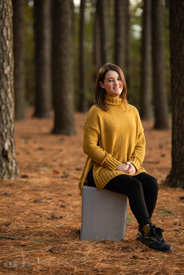 Kent Island High School Maryland senior sitting by pine trees photo by Leo Dj Photography.